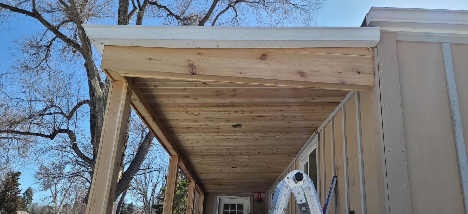 Cedar plank soffit and beam under a new covered porch
