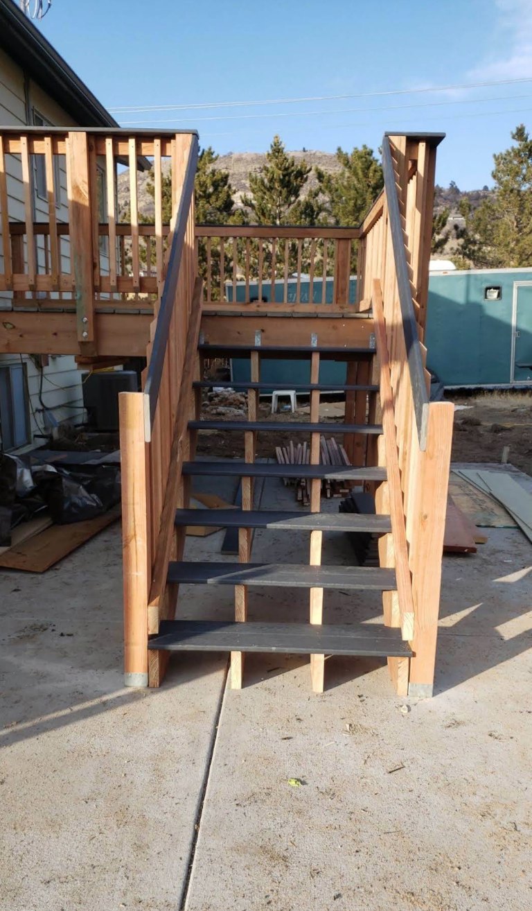 Cedar-railed deck stairs with composite treads against a Colorado foothills backdrop