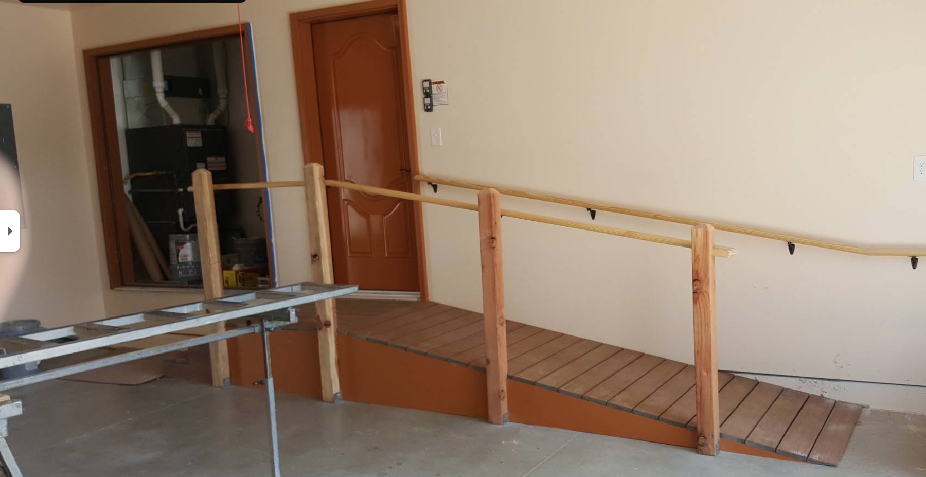 Timber accessibility ramp with handrail built into a garage entry
