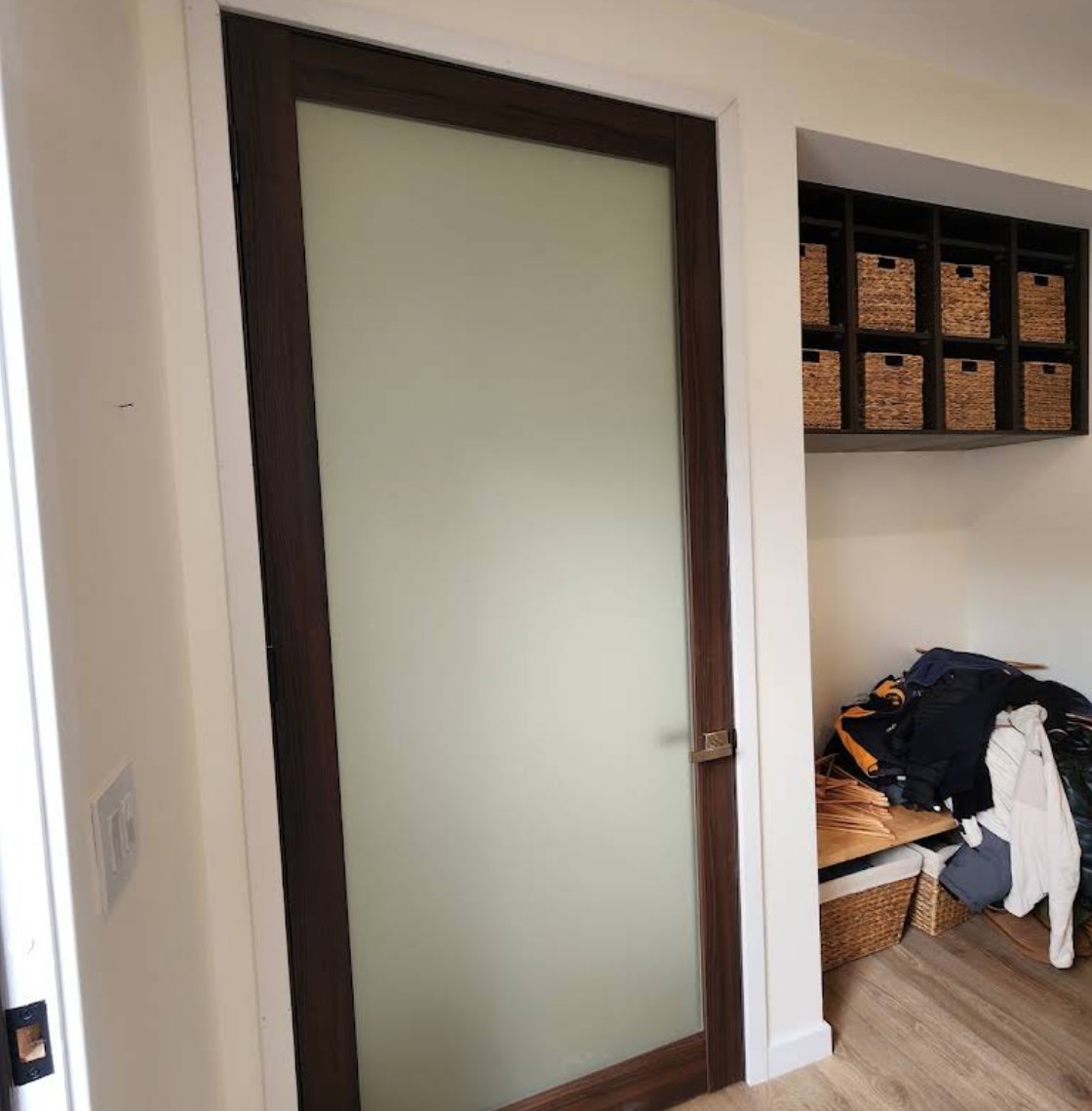 Frosted glass walnut door beside a built-in mudroom cubby unit